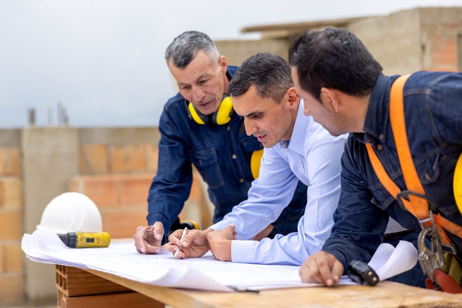 Construction team reviewing blueprints on site.