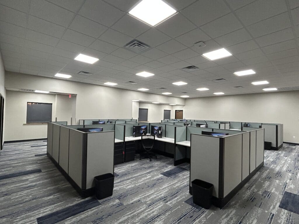 Empty office cubicles under bright ceiling lights