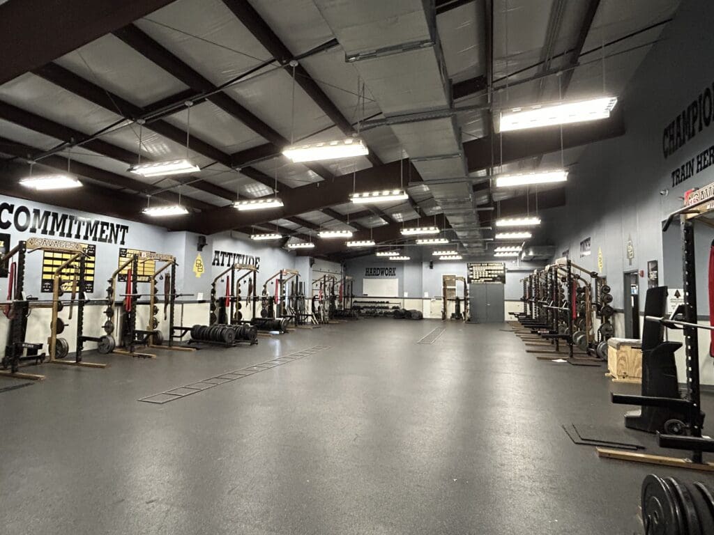 Empty weightlifting gym with racks and barbells